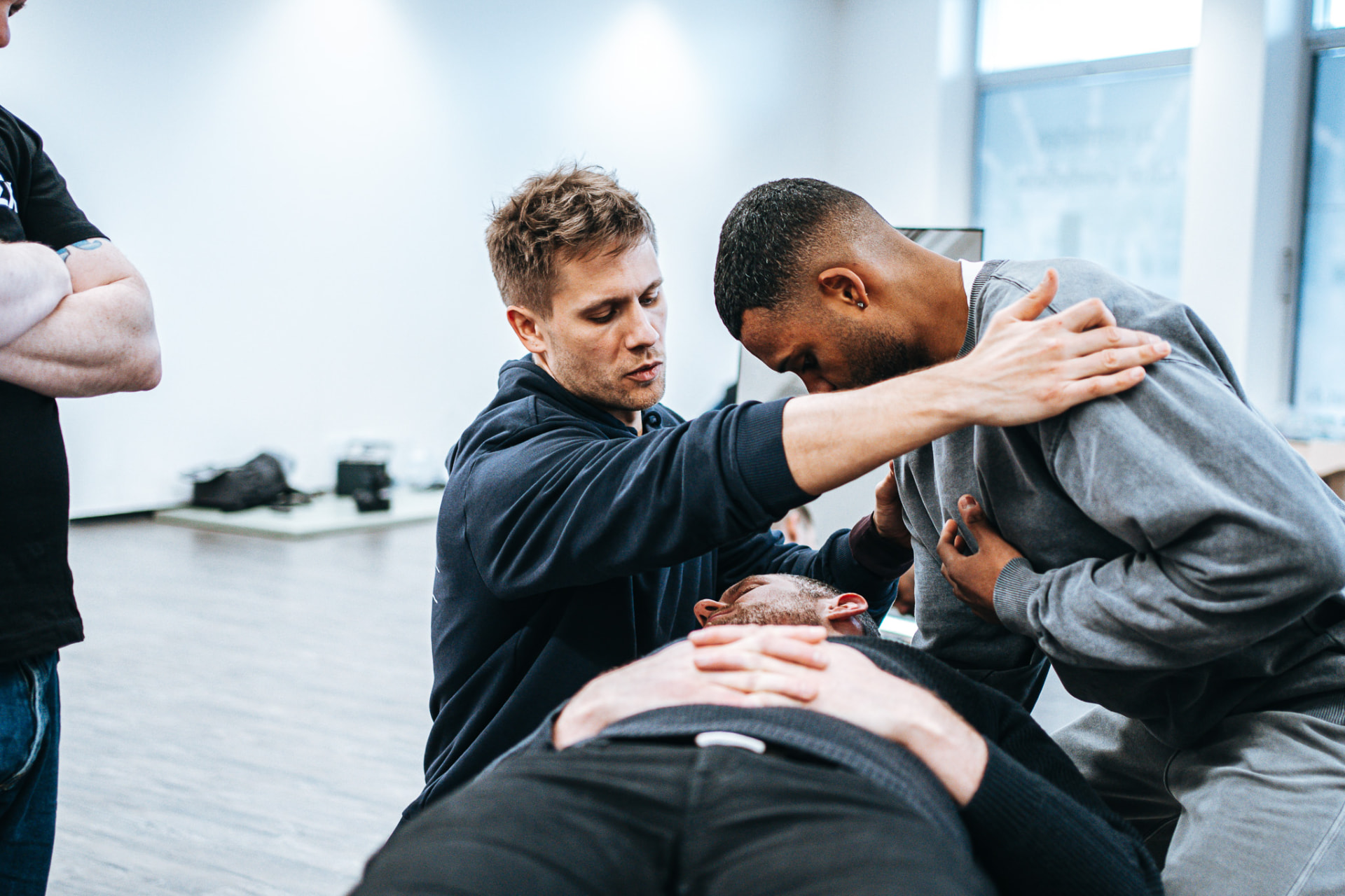 Trainer korrigiert das zervikale Setup eines Teilnehmers im Seminar